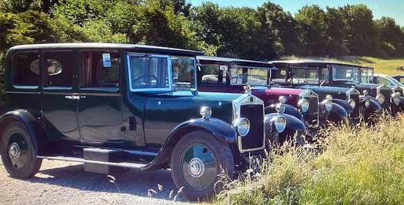 A line of vintage Lanchester motor cars gathered at a rally